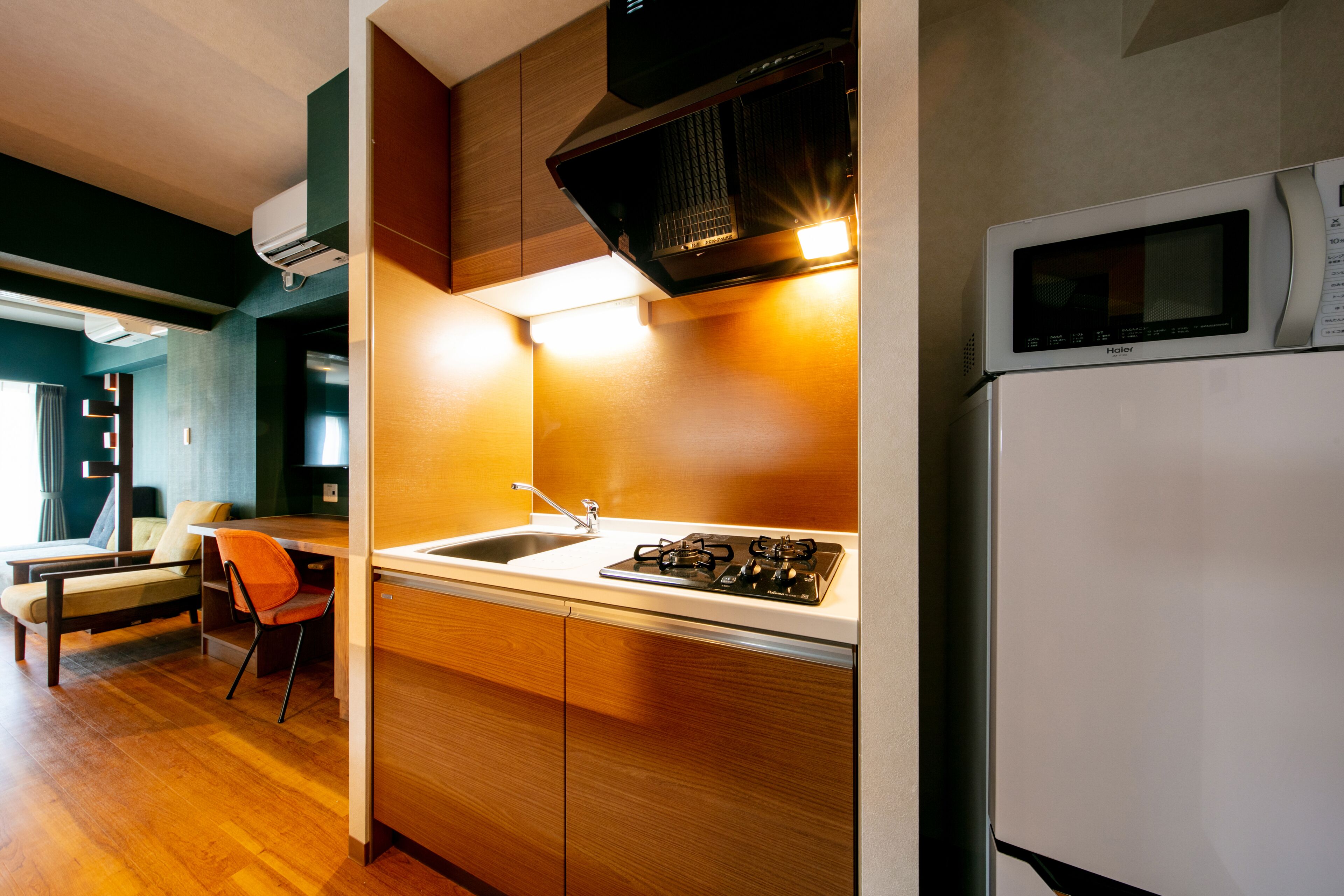 A modern kitchen with a gas stove, sink, and a microwave.