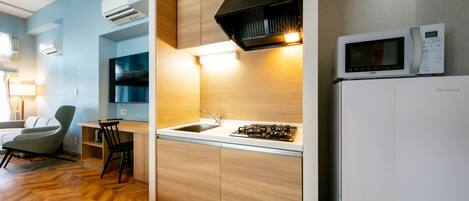 A modern kitchen with a built-in microwave, gas stove, and sink.