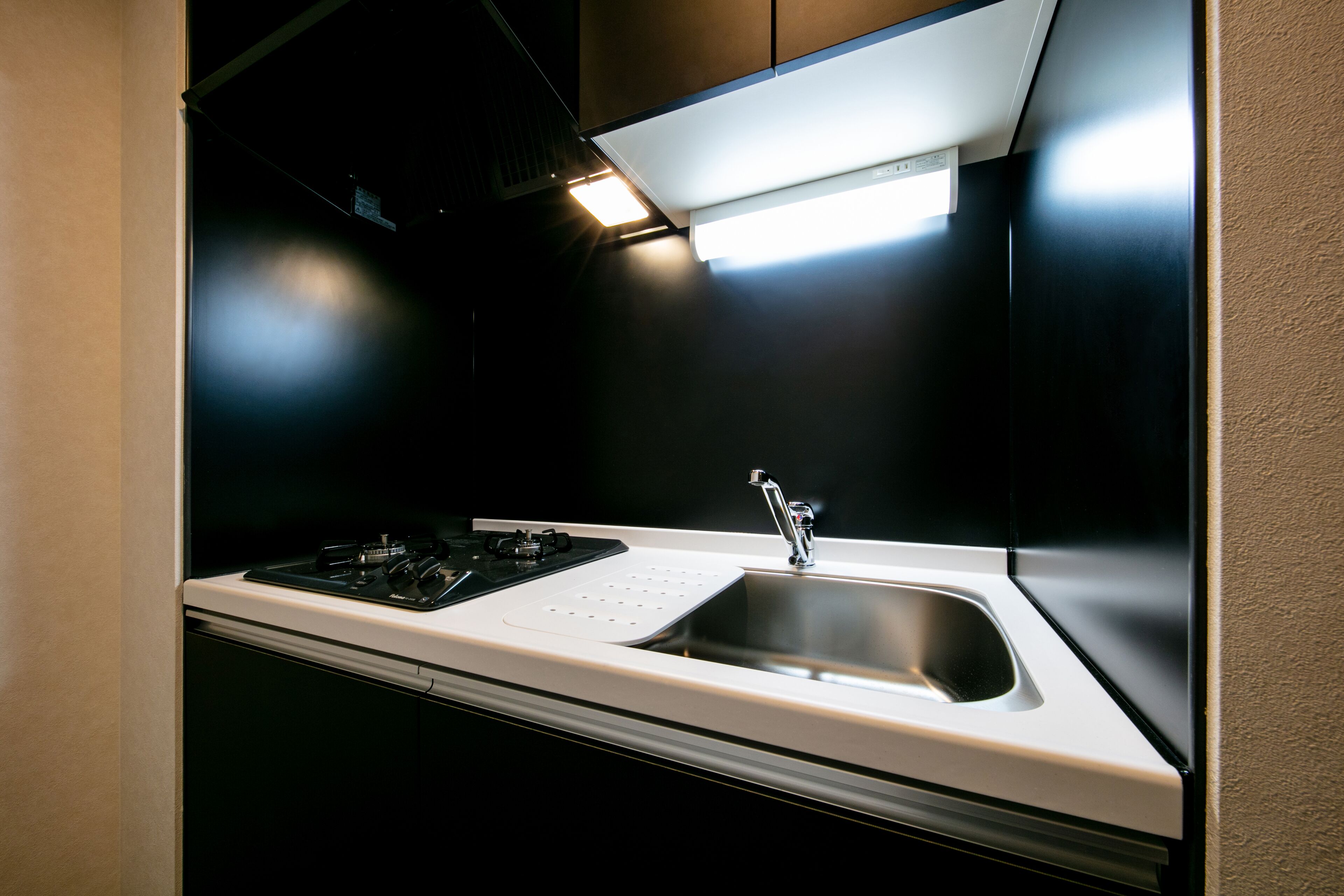 A modern kitchen with a stainless steel sink, a gas stove, and a range hood.
