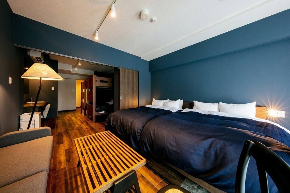A modern hotel room with a large bed, a desk, and a chair.