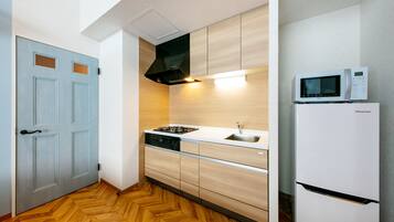 A compact kitchen with a microwave, stove, and dishwasher.