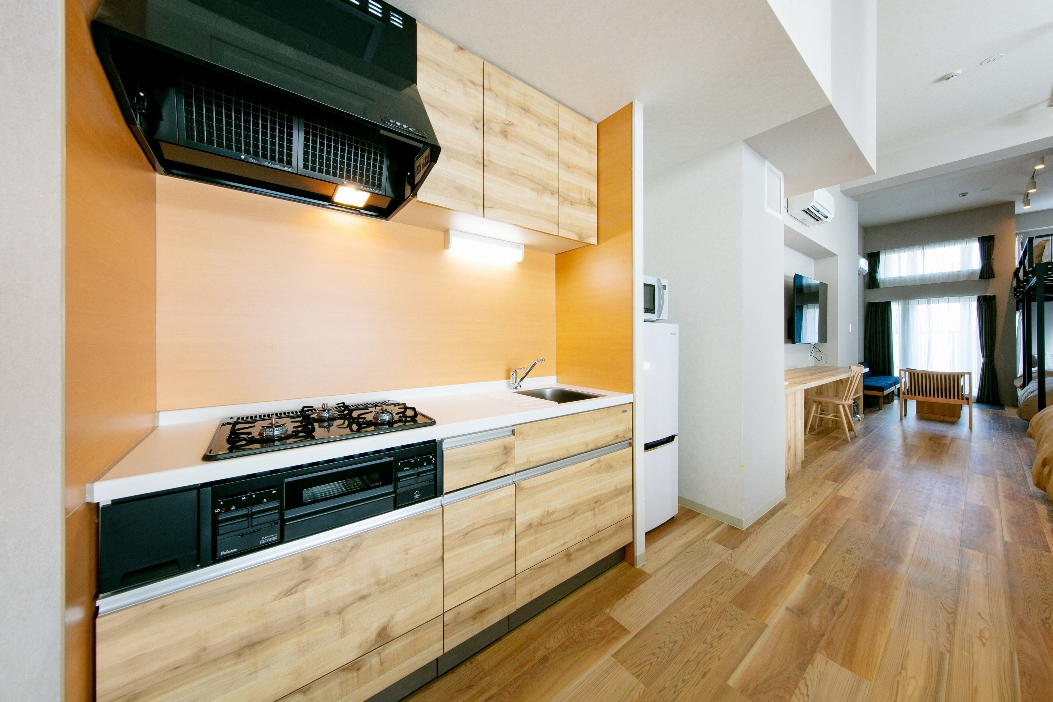 A modern kitchen with wooden cabinets, a built-in dishwasher, and a gas stove.