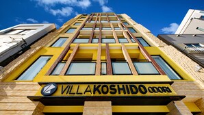 Un edificio con fachada amarilla y el nombre "VILLAKOSHIDO ODORA" claramente visible.