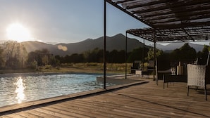 A wooden deck with a pool, outdoor seating, and a pergola. - E case di u Puntale, Villa with swimming pool ideal for family vacations. (Ghisonaccia)