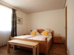 A bedroom with a wooden bed, a bedside table, and a nightstand. - House Andrea B - House Andrea (Meersburg)