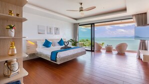 A modern hotel room with a large bed, a balcony with a view of the sea, and a television. - Modern Beachfront Villa near Fishermans Village (Bophut)