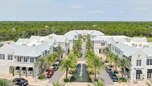Un hotel con un cortile centrale, palme e un elemento d'acqua.