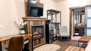 Ein kompakter Wohnbereich mit Kamin, Fernseher, Essbereich und Sitzecke.