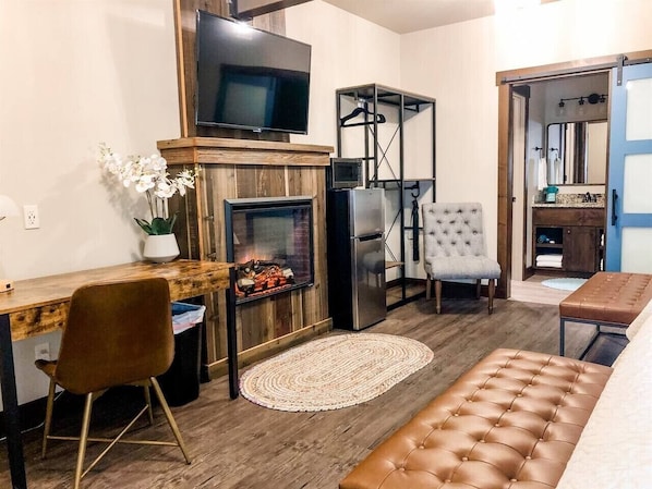 A compact living space with a fireplace, a television, a dining area, and a seating area.