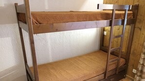 Un lit superposé avec une structure en bois et une literie marron.