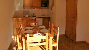 Una cocina compacta con armarios de madera, un microondas y un lavavajillas.