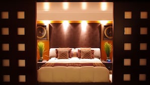 A modern bedroom with a large bed, two bedside tables, and a wall clock. - Posh & Lavish ... 2 ADJOINING SUITES ... Direct Ocean Views (Honolulu)