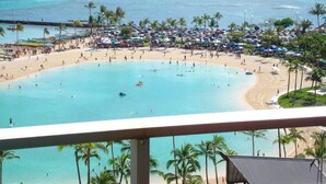 A beach resort with a large pool, palm trees, and a view of the ocean. - Posh & Lavish ... 2 ADJOINING SUITES ... Direct Ocean Views (Honolulu)