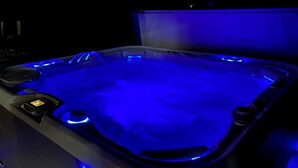 A hot tub with blue lighting. - Family Waves with beach on Lake Winnipesaukee! (Meredith)