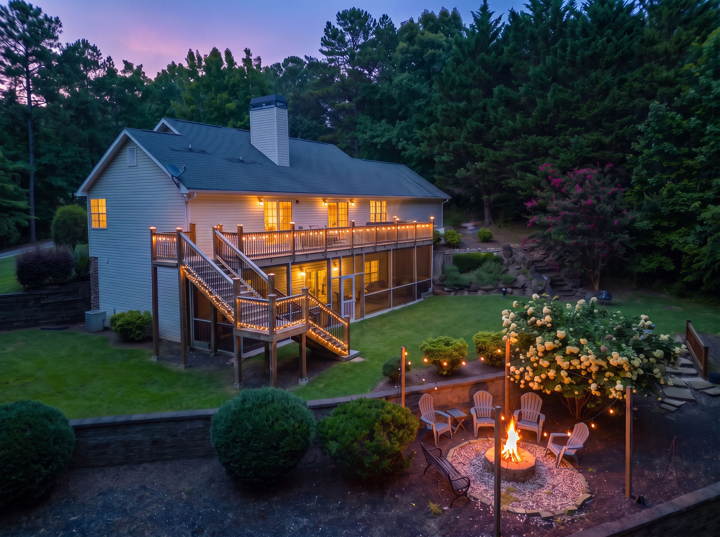 A two-story house with a deck, a fire pit, and outdoor seating.