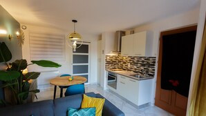 A compact living space with a sofa, dining table, and kitchenette. - THE DOLCE VITA SUITE (Sin-le-Noble)