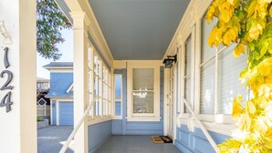 A porch with a blue door, white trim, and a number '124' on the wall. - Fountain Avenue - Pacific Grove Apartment - Steps to the Sea (Pacific Grove)