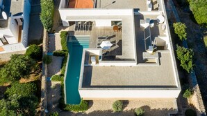 A modern house with a swimming pool, outdoor seating, and a garden. - Villa “Ses Alzines” with Sea View, Pool, A/C, Wi-Fi, Balcony, Garden & Terrace (Sant Lluís)
