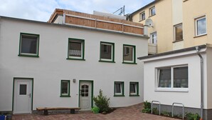 En byggnad med flera fönster, en dörr och en liten utesittplats.