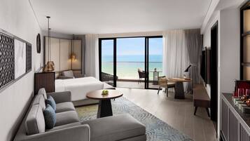 A modern hotel room with a balcony, a sofa, a dining table, and a TV.