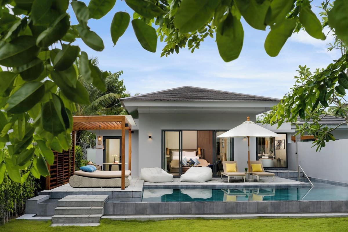 Een modern huis met zwembad, terras en overdekte patio.