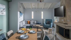 Un salon moderne comprenant un coin repas, une cheminée et un téléviseur.