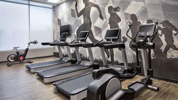 A gym with treadmills, elliptical machines, and a stationary bike.