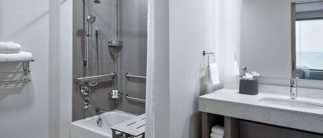 A modern bathroom with a walk-in shower, a bathtub, and a vanity with a mirror.