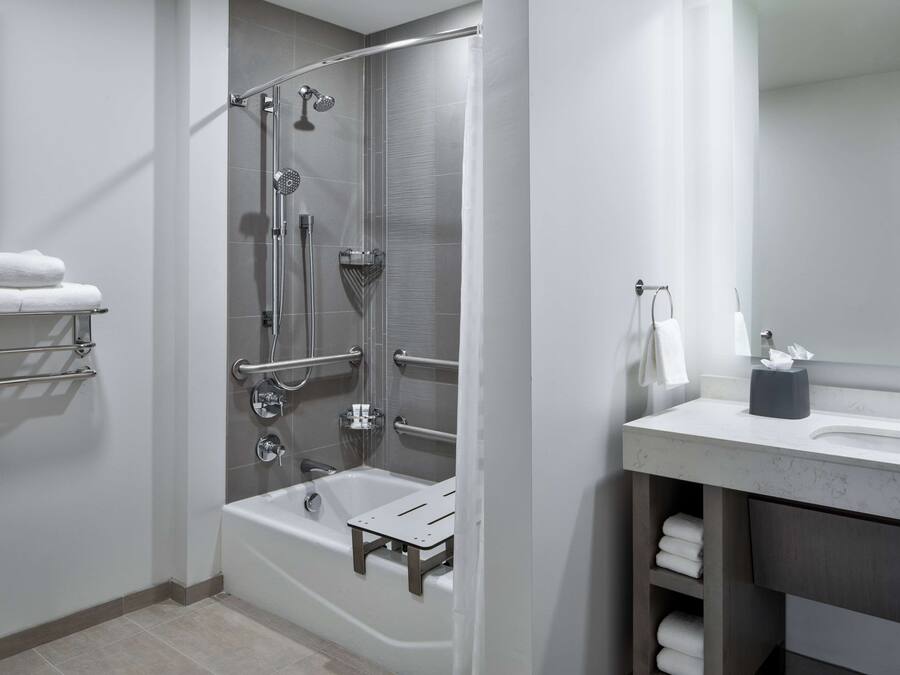 Een moderne badkamer met een inloopdouche, een badkuip en een wastafel met spiegel.