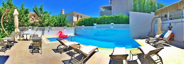 Alberca al aire libre, sombrillas en la alberca y camastros 