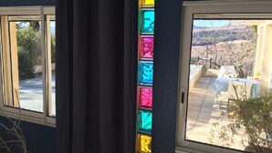 Une pièce dotée de deux fenêtres, dont l’une offre une vue sur un paysage enneigé et l’autre sur un patio.