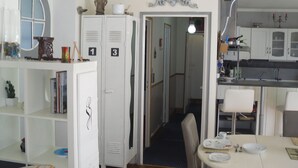 A compact living space with a kitchenette, a dining area, and a small hallway leading to another room. - Gites de Daumesnil 5 minutes walk from town center. (Morlaix)