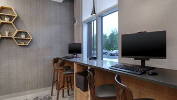 Un espacio de oficina moderno con un escritorio, dos monitores, un teclado y dos sillas. Hay estanterías hexagonales con objetos decorativos en la pared y un ventanal con vistas al exterior.