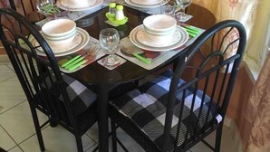 A dining table set for six with black chairs, white plates, and green napkins. - 1 Bed Villa - Sleeps 2 - Garden - Parking - Wifi (Ocho Rios)
