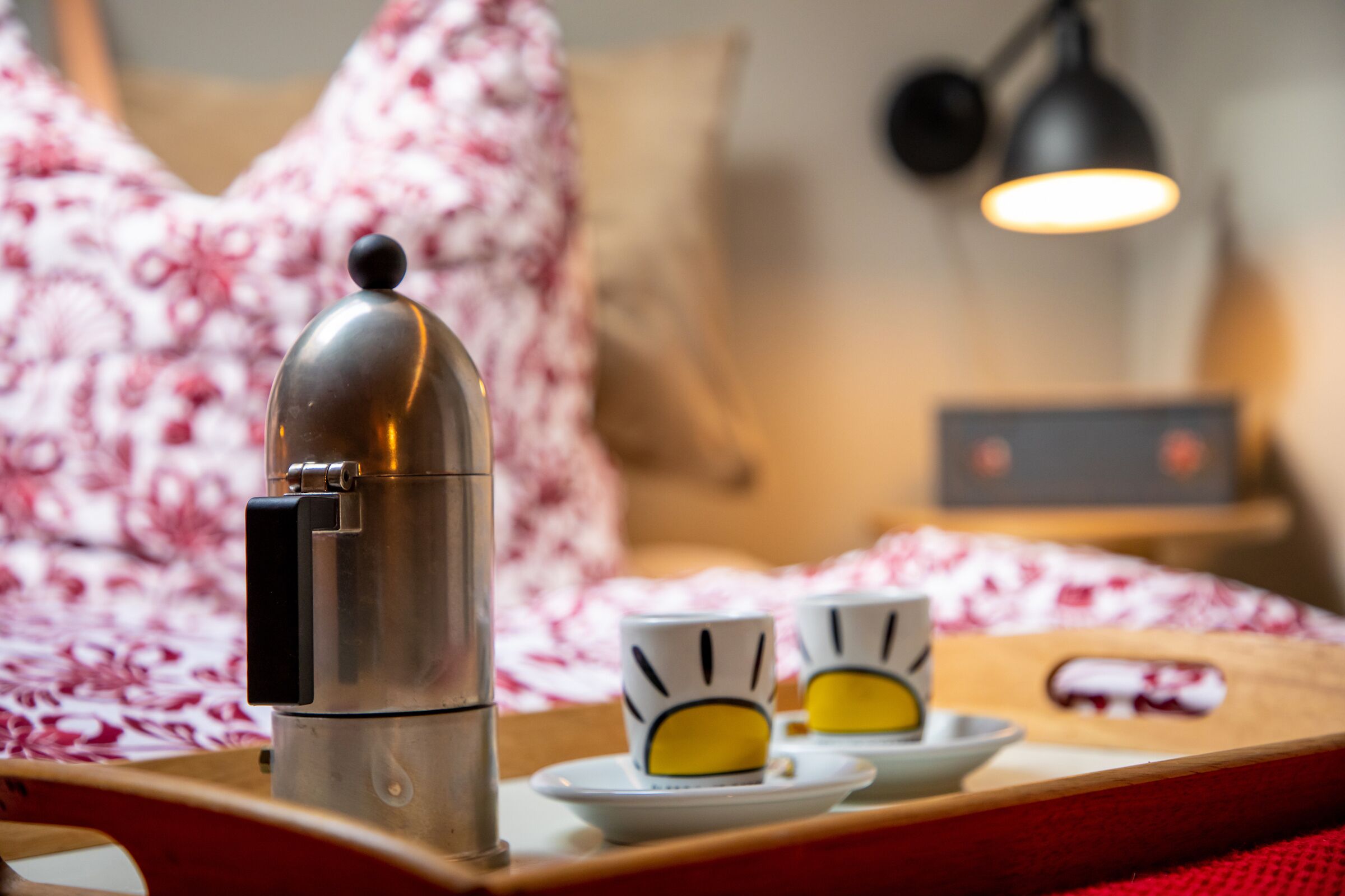A coffee maker, two cups, and a tray in a hotel room.