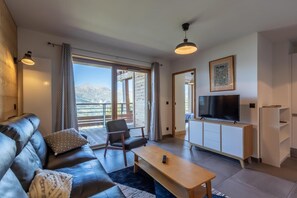 Relax in this stylish living room with a comfortable sofa, flat-screen TV, and beautiful views of the outdoors.