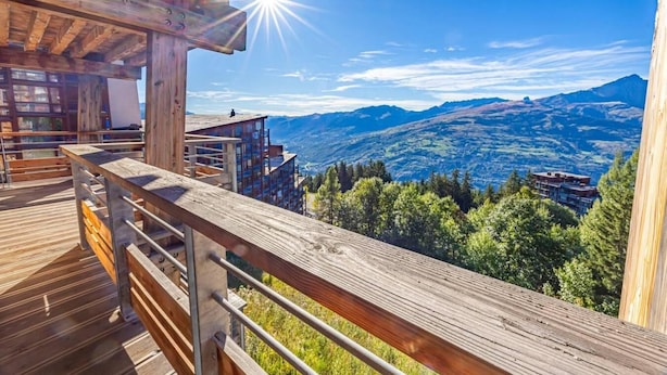 A wooden deck with a metal railing overlooking a mountainous landscape. - 100m from ski slopes, floor -1, view valley, fitness, sauna, hammam, terrace, parking, tv (Bourg-Saint-Maurice)