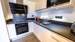 A modern kitchen with a built-in oven, a microwave, and a coffee maker. - 100m from ski slopes, floor -1, view valley, fitness, sauna, hammam, terrace, parking, tv (Bourg-Saint-Maurice)