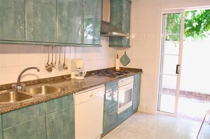 Enjoy cooking in this well-equipped kitchen with a double sink, coffee maker, and stove, just steps from the outdoor area.