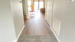 A hallway with a carpet, a lamp, and a door with a sign. - Remington Family Fun Comfort & Sunshine – 4BR Villa w/ Pool (Osceola County)