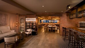 Un interno moderno con un'area bar, posti a sedere e una teca con riconoscimenti.