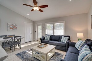 A living room with a sofa, coffee table, and a ceiling fan.