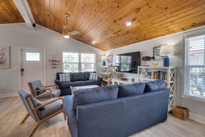A living room with a wooden ceiling, a sofa set, a TV, and a bookshelf. - Anchor Splash (Anna Maria)