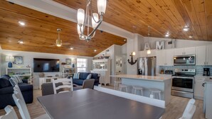 Una cocina moderna con armarios blancos, una isla grande y electrodomésticos de acero inoxidable.