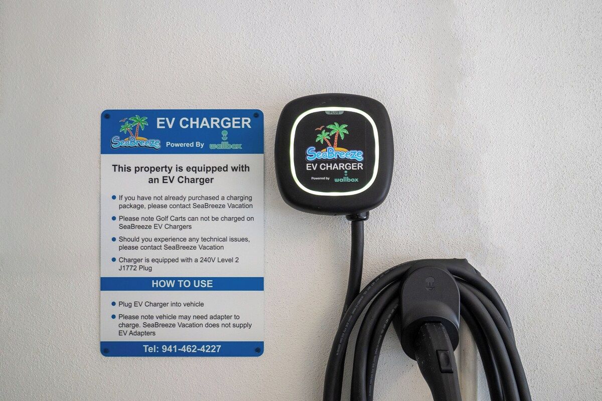 Eine EV-Ladestation mit einem Schild, das ihre Funktionen und Gebrauchsanweisung erklärt.