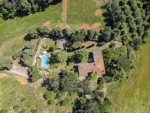 An aerial view of a property with a swimming pool, a large house with a sloped roof, and surrounding greenery. - Casa Ciculino 8, Emma Villas (Monteleone D'orvieto)