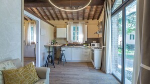 A modern kitchen with a wooden ceiling, large windows, and a dining area with stools.