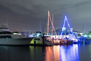 A marina at night with boats docked, illuminated by colorful lights. - Tropical Waterfront Villa with Heated Pool & Spa (Punta Gorda)
