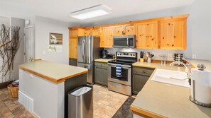 Enjoy cooking and meal preparation in this well-equipped kitchen with a refrigerator, microwave, oven, and sink.