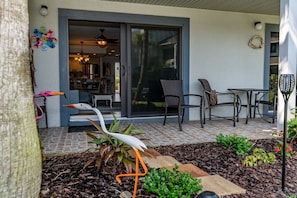 Enjoy the serene garden and outdoor seating area with a sliding glass door leading to the interior space.